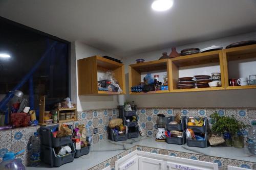 a kitchen with wooden cabinets and a tiled counter top at Hostel The Endless House Anchor point in Taghazout