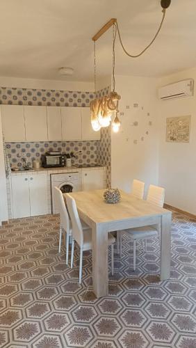 a kitchen with a dining room table with white chairs at Casa Leone in Stintino