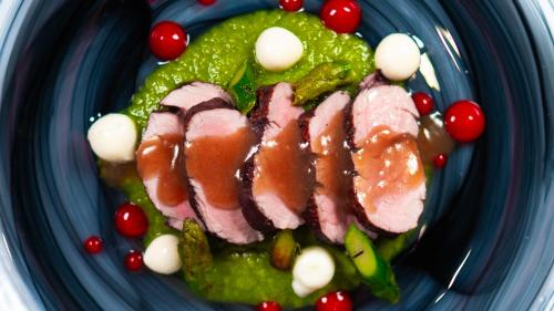 a plate of food with meat and berries on it at Altafiumara Resort & Spa in Villa San Giovanni
