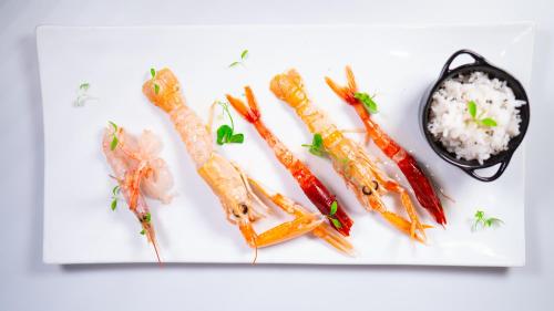 a white plate of food with carrots and rice at Altafiumara Resort & Spa in Villa San Giovanni