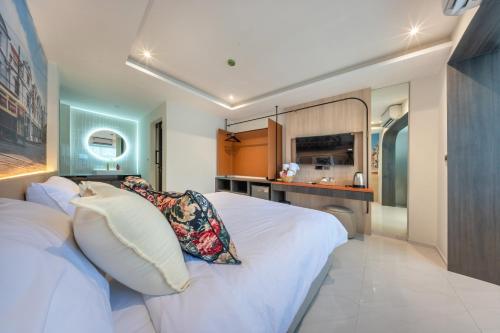 a bedroom with a white bed and a kitchen at U TOR Yaowarat in Bangkok