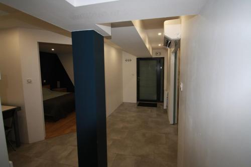 un couloir avec une chambre dotée d'un lit et d'un pôle bleu dans l'établissement Appartement rénové, à Beaune