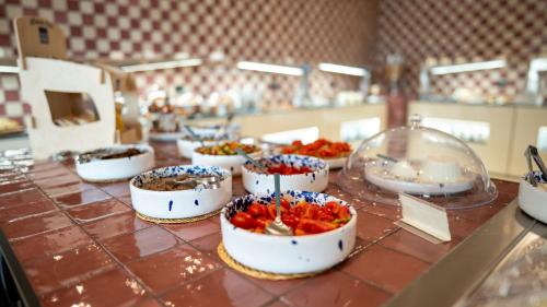a buffet with bowls of food on a table at Altafiumara Resort & Spa in Villa San Giovanni