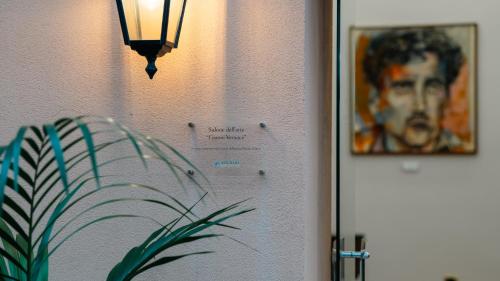 a picture of a man on the wall next to a lamp at Altafiumara Resort & Spa in Villa San Giovanni