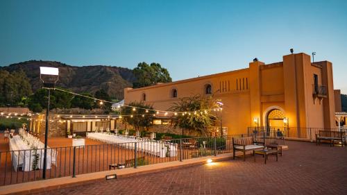 a building with tables and chairs in front of it at Altafiumara Resort & Spa in Villa San Giovanni