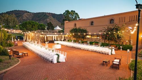 a row of white tables and chairs in front of a building at Altafiumara Resort & Spa in Villa San Giovanni
