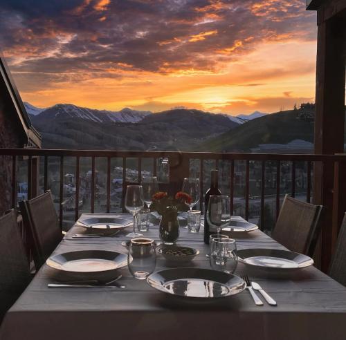 una mesa con platos y copas de vino en el balcón en True Ski-In & Out, Panoramic Mtn Views, 3Bdm, en Crested Butte