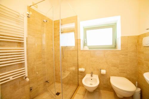 a bathroom with a shower and a toilet and a sink at Coppola di Seta in Locorotondo