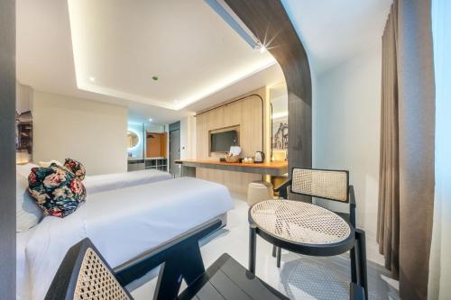 a bedroom with a bed and a table and chairs at U TOR Yaowarat in Bangkok
