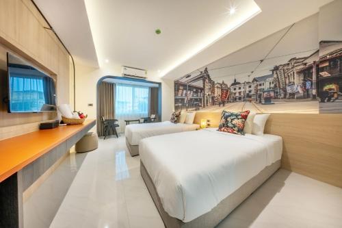 a hotel room with a bed and a tv at U TOR Yaowarat in Bangkok