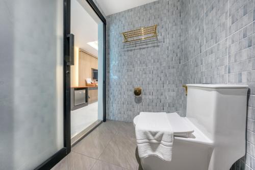 a bathroom with a white toilet in a room at U TOR Yaowarat in Bangkok