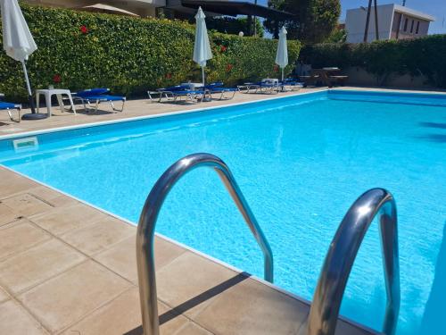 a swimming pool with blue water in a hotel at Sunset Green 01 in Paphos City