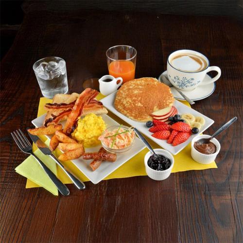 a plate of breakfast food with pancakes and a cup of coffee at Bmi Florence rooms in Florence