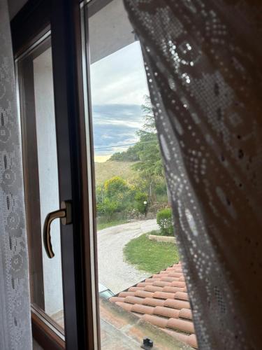 a glass door with a view of a road at B&B castelboccione stanza gialla condivisa in Il Palazzone