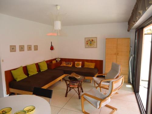 un salon avec un canapé, une table et des chaises dans l'établissement Bel appartement 2 pièces proche plages et commerces, à Cavalaire-sur-Mer