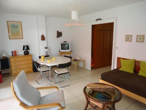 - un salon avec un lit et une table avec des chaises dans l'établissement Bel appartement 2 pièces proche plages et commerces, à Cavalaire-sur-Mer