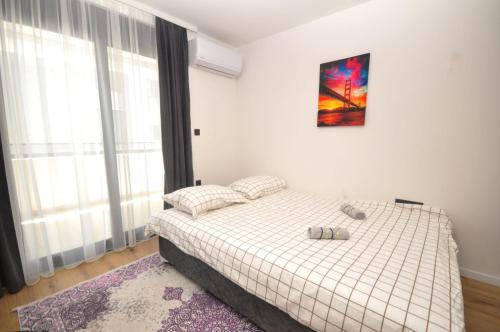 Un dormitorio con una cama y un cuadro en la pared. en Studio Dobra Voda 13, en Dobra Voda