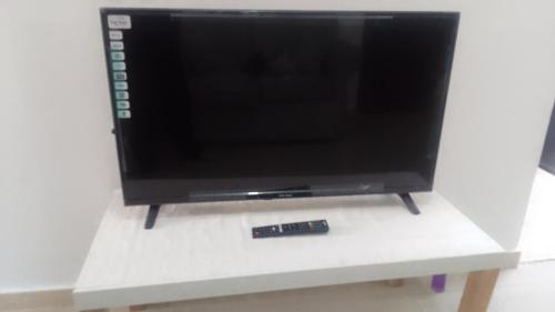 a flat screen tv on a stand with a remote control at للايجار استديو مفروش في ابوظبي منطقه الوحده مول in Abu Dhabi
