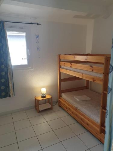une chambre avec un lit superposé et une table dans l'établissement Villa des Alizés, au Cap d'Agde