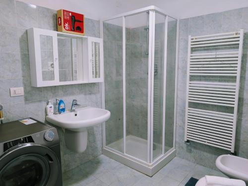 a bathroom with a shower and a sink and a washing machine at Venice Luxury Apartment in Venice