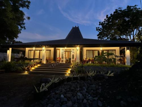 a house with lights in front of it at night at Kampung Kecil Beach Front Boutique Hotel in Kubu