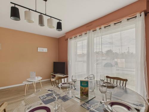 une salle à manger avec une table et des chaises et une fenêtre dans l'établissement Maison pour 6 personnes à Saint-Hilaire-de-Riez, à Saint-Hilaire-de-Riez