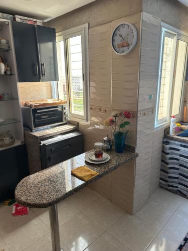 a kitchen with a counter and a clock on the wall at Ahmed 205 in Temara