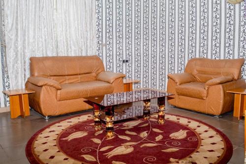 a living room with two chairs and a coffee table at Aloha Hotel & Resort in Oshogbo