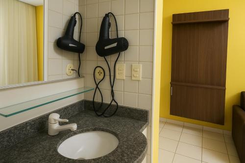 a bathroom with a sink and a phone on the wall at Yatch Village Flat in Natal
