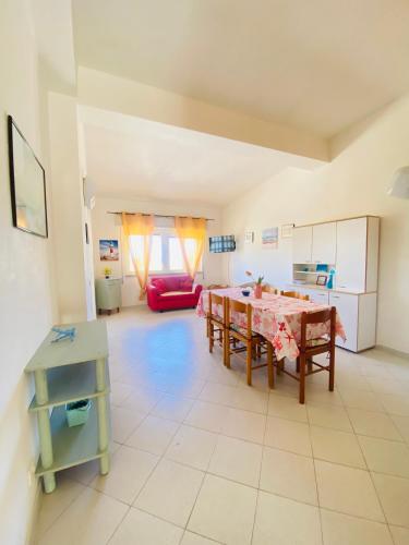 a living room with a table and a red couch at Appartamento Fronte Mare Marzamemi in Marzamemi