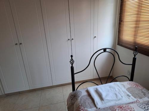a bedroom with a bed and white cabinets at Sunset Green 01 in Paphos City