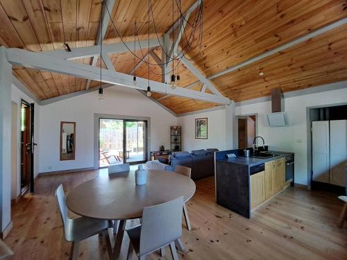 Il comprend un grand salon avec une table et une cuisine. dans l'établissement La Canopée, à Lit-et-Mixe
