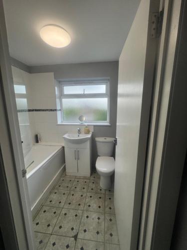 a bathroom with a toilet and a tub and a sink at North London Room in Enfield Lock