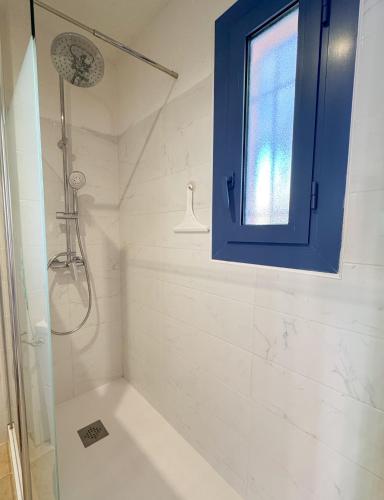 La salle de bains est pourvue d'une douche et d'une fenêtre bleue. dans l'établissement Jolie Studio dans Village de vacances - Miami 26, à Canet