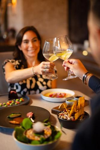 a woman sitting at a table with a glass of wine at NIZUC Resort & Spa in Cancún