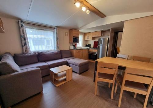un salon avec un canapé et une table dans l'établissement LOCATION MOBIL HOME 40m carré de 2 à 8 personnes en bords de mer, à Saint-Brévin-lʼOcéan