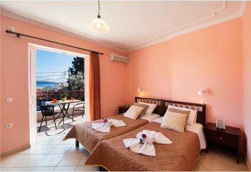 a hotel room with two beds and a balcony at Sunrise studios Lefkada in Nydri
