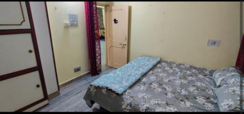 a bedroom with a bed with a blue comforter at Lakeview Flat-Dargah,Pushkar 10mins away in Ajmer