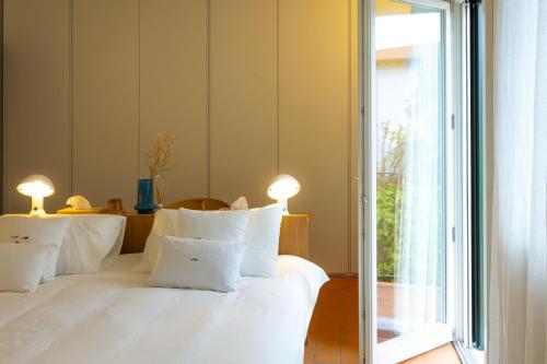 a bedroom with a white bed with white pillows at Lunavi in Forte dei Marmi