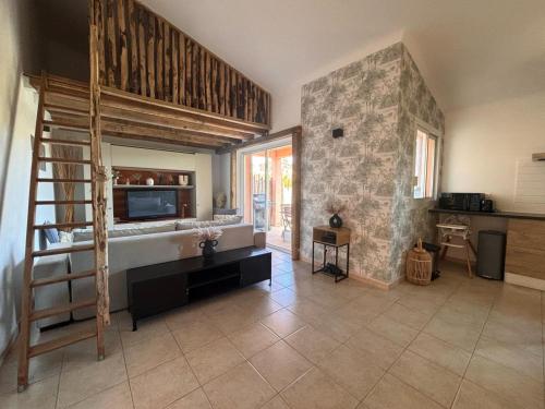 une chambre avec une cuisine et un salon avec une échelle dans l'établissement Appartement 2 chambres, mezzanine et piscine, à Porto-Vecchio