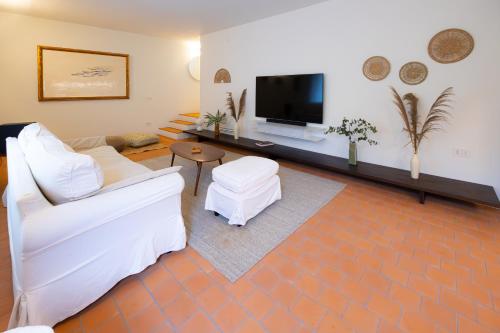 a living room with white furniture and a flat screen tv at Lunavi in Forte dei Marmi