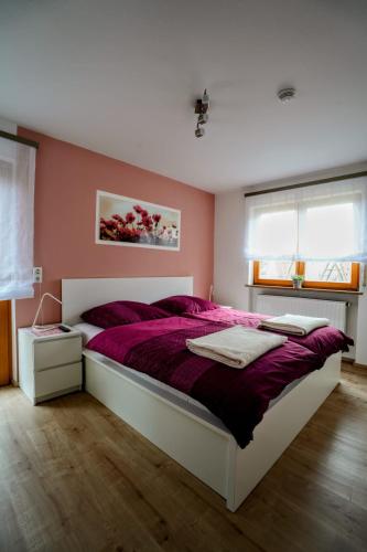 a bedroom with a large bed with a purple blanket at Ferienwohnung Zur Wolfskehln in Viereth-Trunstadt