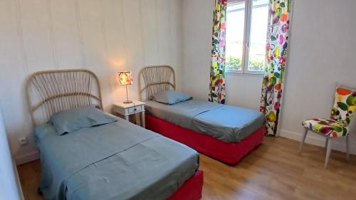 une chambre avec deux lits et une chaise et une fenêtre dans l'établissement Villa Iris, climatisée avec 4 chambres et piscine à Boulouris sur Mer, à Saint-Raphaël