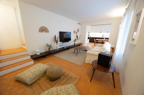 a living room with a couch and a tv at Lunavi in Forte dei Marmi