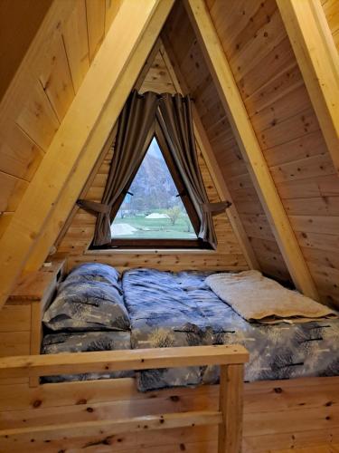 ŠavnikにあるWooden cottages KONAKの窓付きのログキャビン内のベッドルーム1室
