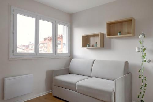 - un salon blanc avec un canapé et une fenêtre dans l'établissement Studio cosy calme de 14 m2 - Plein centre, à Toulouse