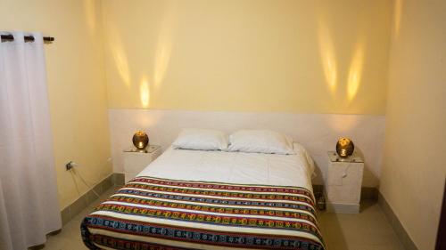 a bedroom with a bed with two night stands at Cabañas SAL Y PIEDRA in Uyuni