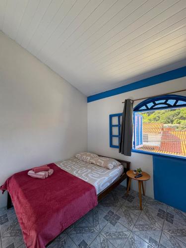 een kleine slaapkamer met een bed en een raam bij Kitnet Brava 2 in Búzios