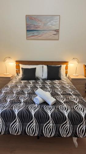 a bedroom with a black and white bed with two pillows at Diamond House Motor Inn in Stawell