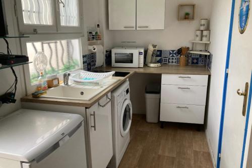 une petite cuisine avec un évier et une machine à laver dans l'établissement Studio of 18 m2 with terrace in Cannes La Bocca, à Cannes